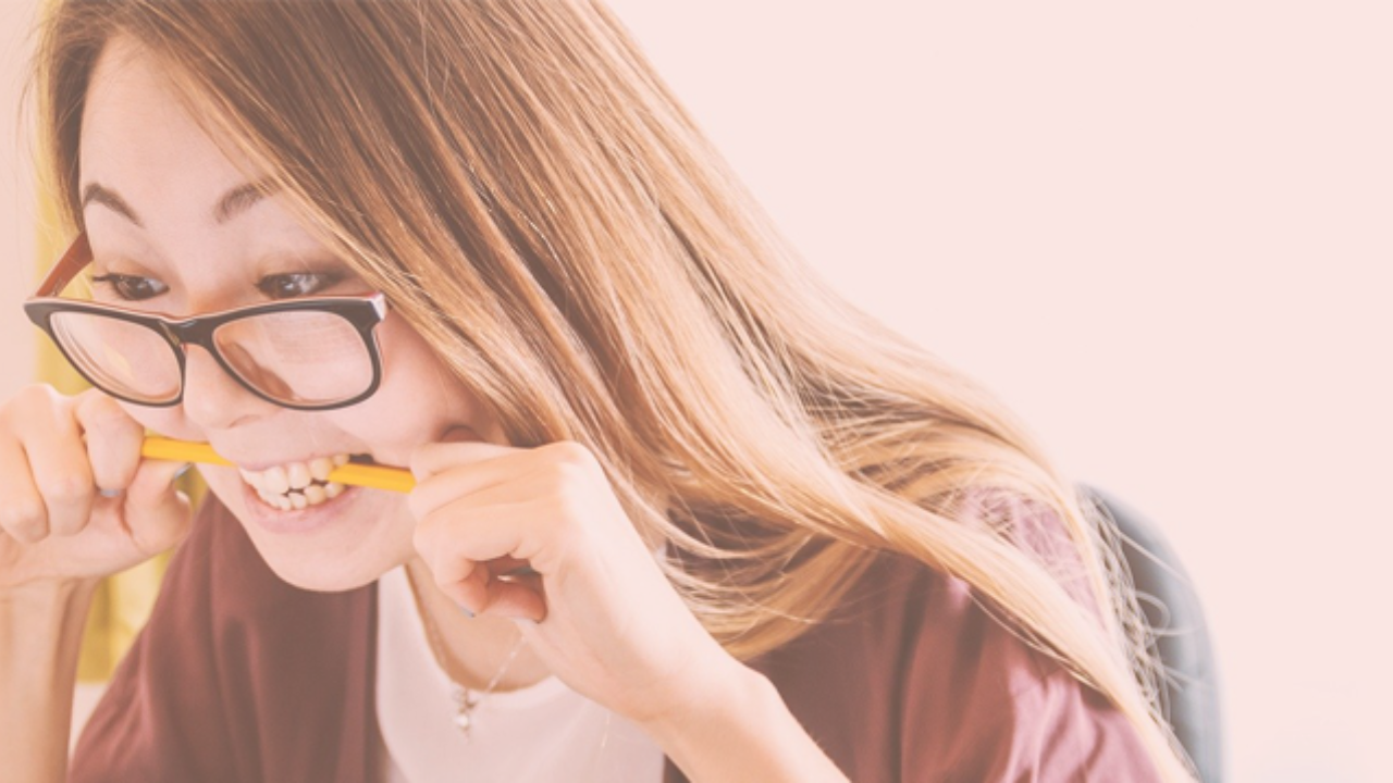 A woman biting a pencil because of stress