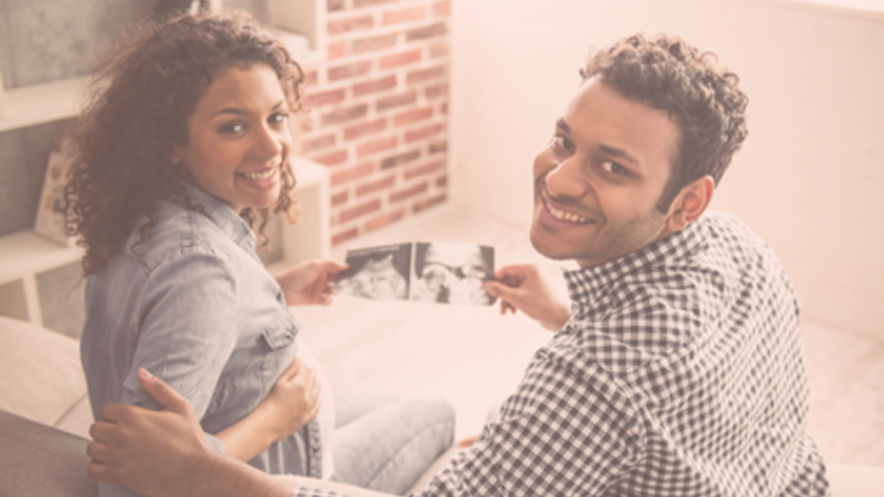 A happy couple holding their baby's scans