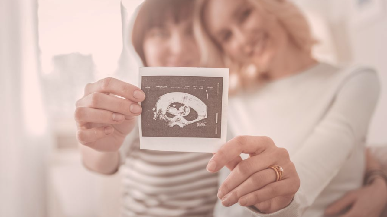 A female same-sex couple showing their ultrasound scans