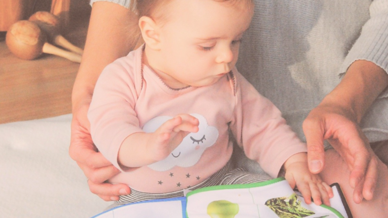 A mom showing her baby a book