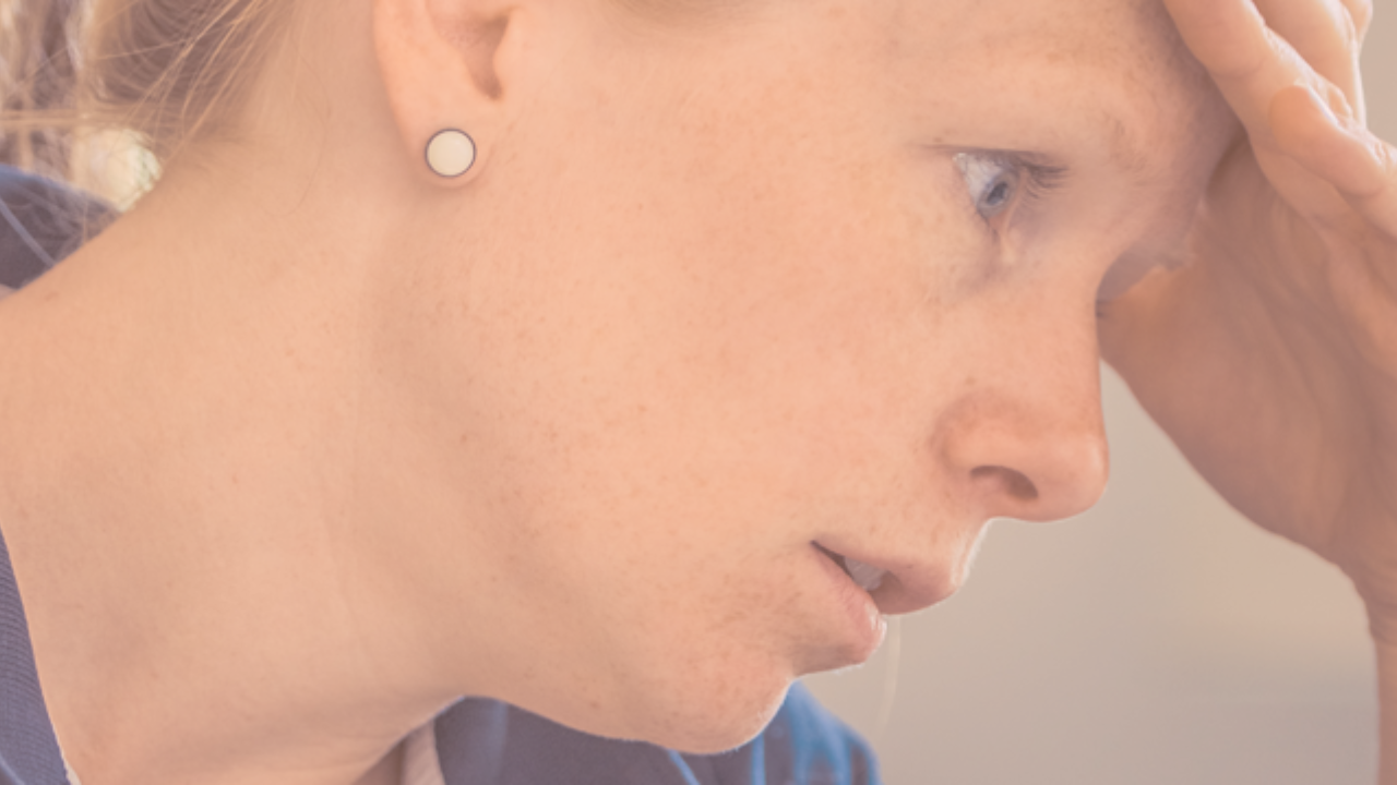 a lady with her hand on her forehead looking worried