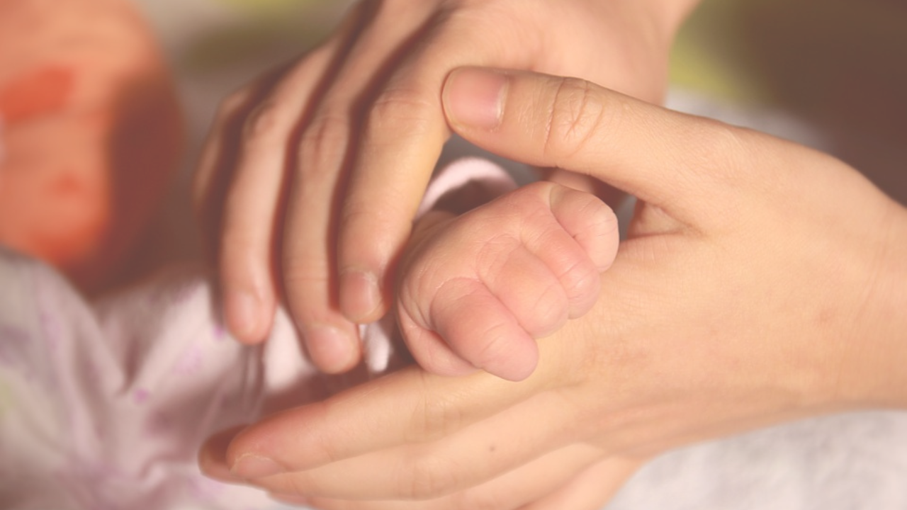 a mom holding a baby's hand