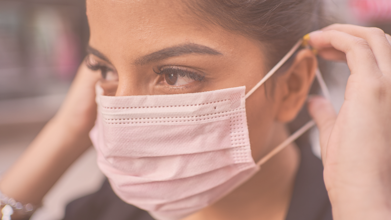 A woman putting on a mask