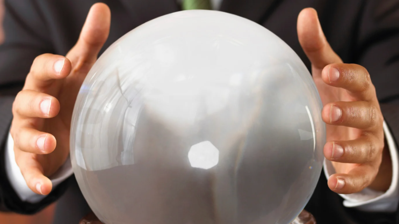 Hands hovering over a crystal ball