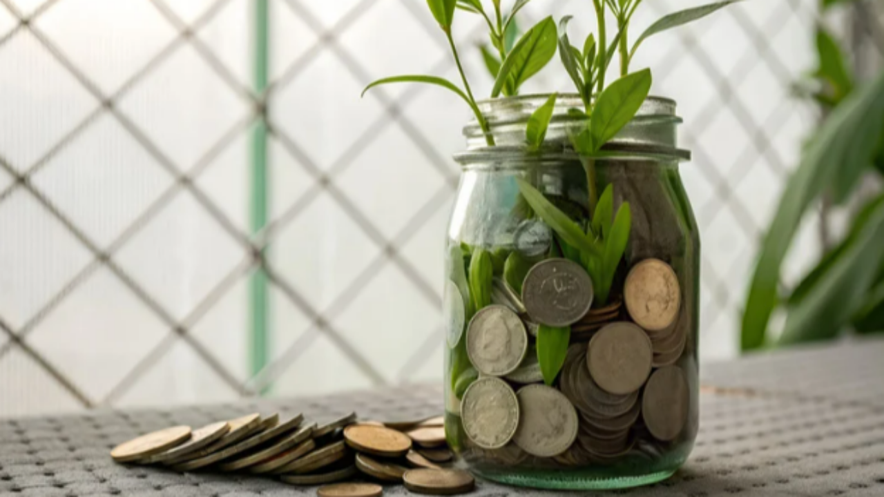 A simple mason jar labeled “Financial Peace” sitting on a desk beside a plant — symbolizing calm, abundance, and grounded money habits.