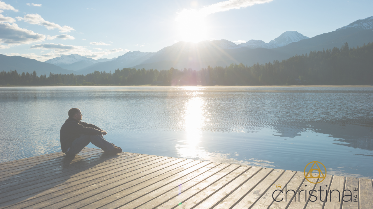 Person looking at sunset on cliff overlooking the ocean