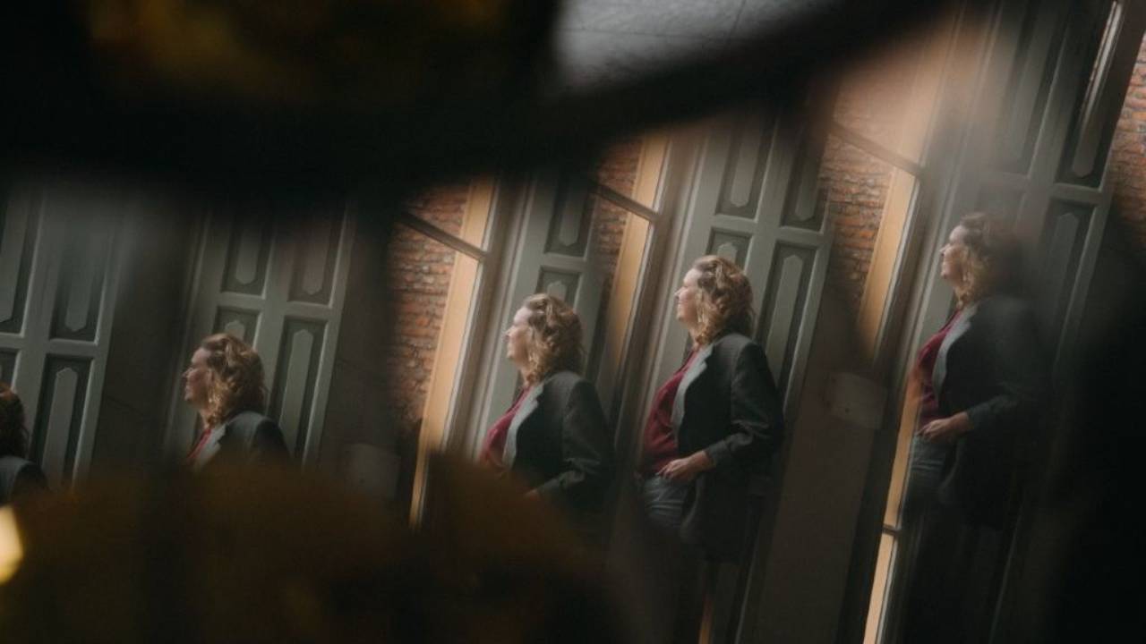 Coach voor vrouwen Esther van Hemert weerspiegeld in een glazen oppervlak, symbool voor herhaling, zelfreflectie en het doorbreken van oude patronen.