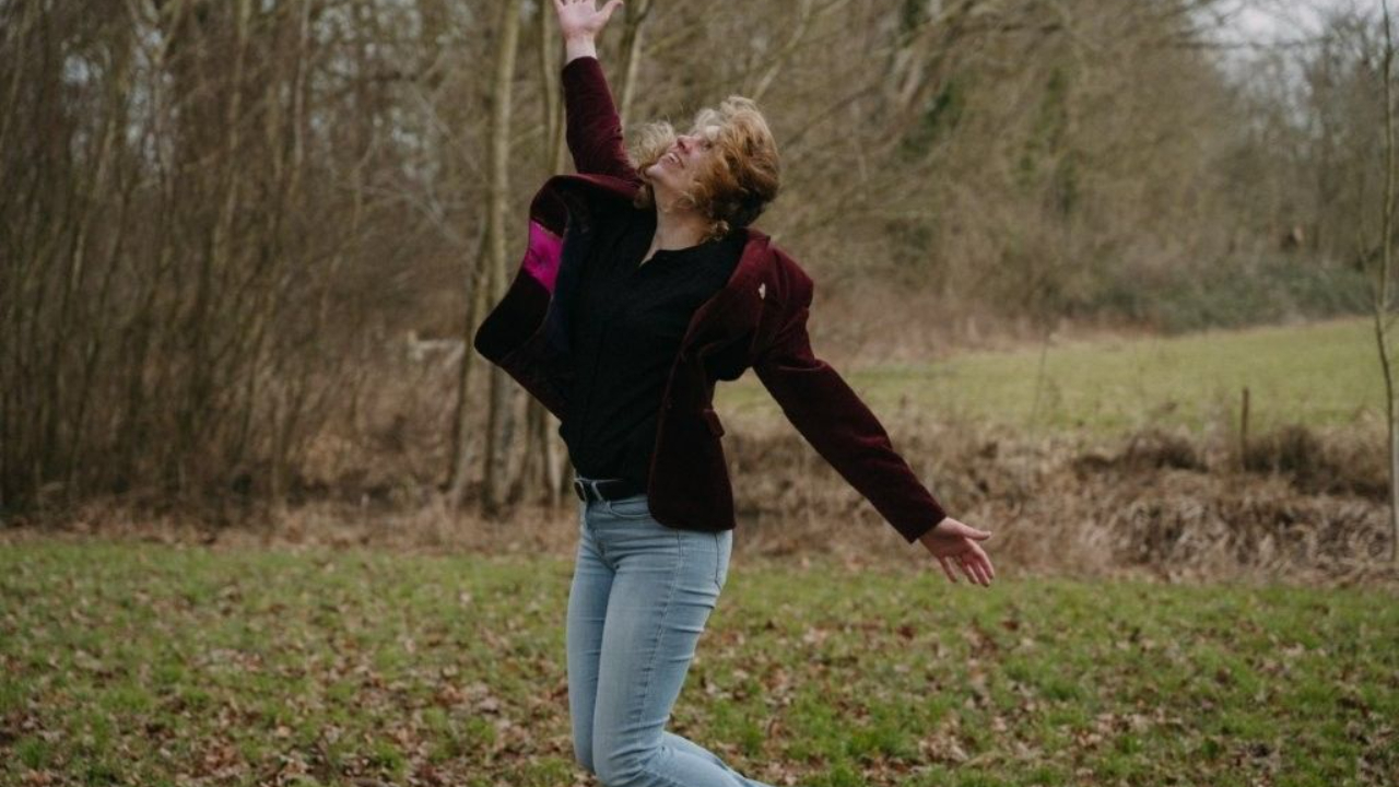 Coach voor vrouwen Esther van Hemert beweegt vrij met open armen in de natuur, symbool voor eigenaarschap, zelfexpressie en innerlijke vrijheid