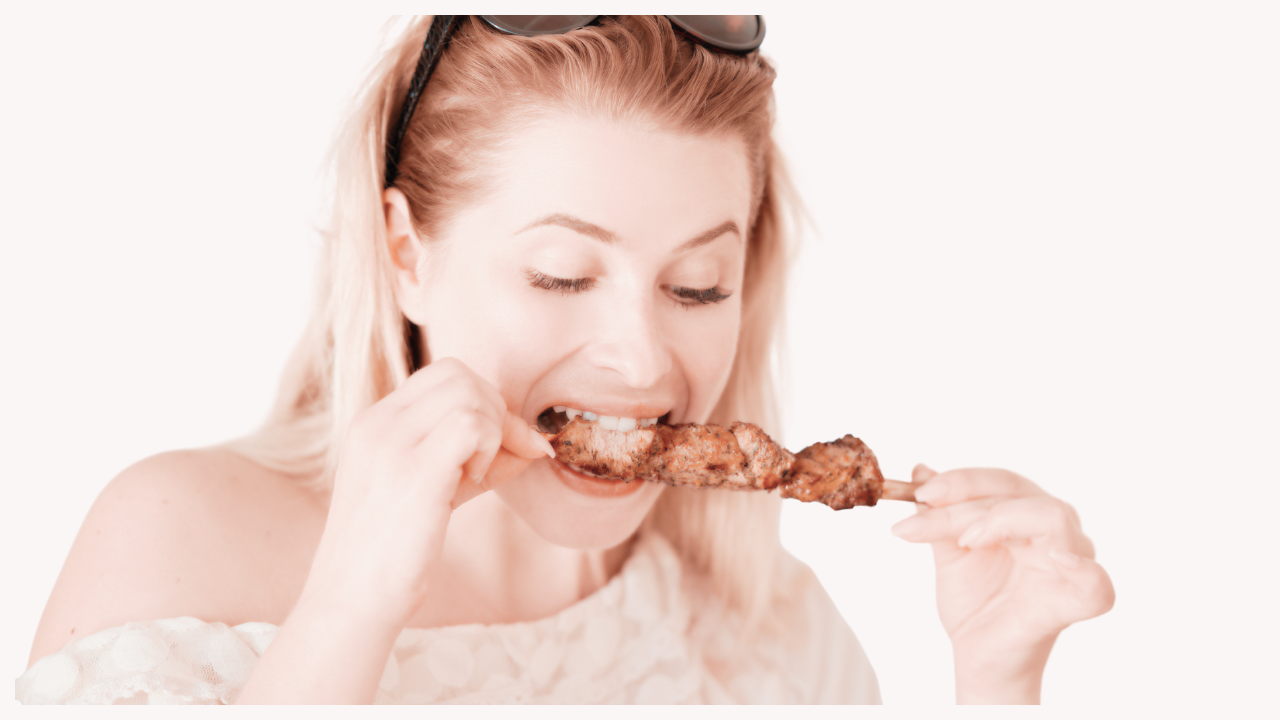 woman eating chicken skewer