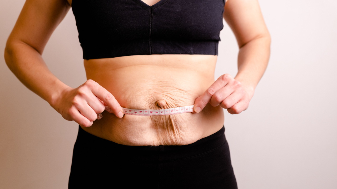 Woman performing a controlled core exercise (deadbug or similar) with good form.  Woman performing postnatal core exercise -- diastasis recti recovery focus on function
