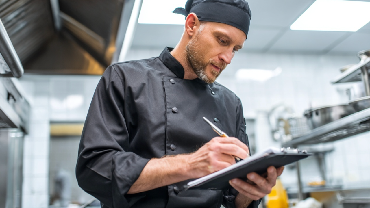 Chefkoch kalkuliert Zutaten zur Wareneinsatzoptimierung in der Gastronomie.