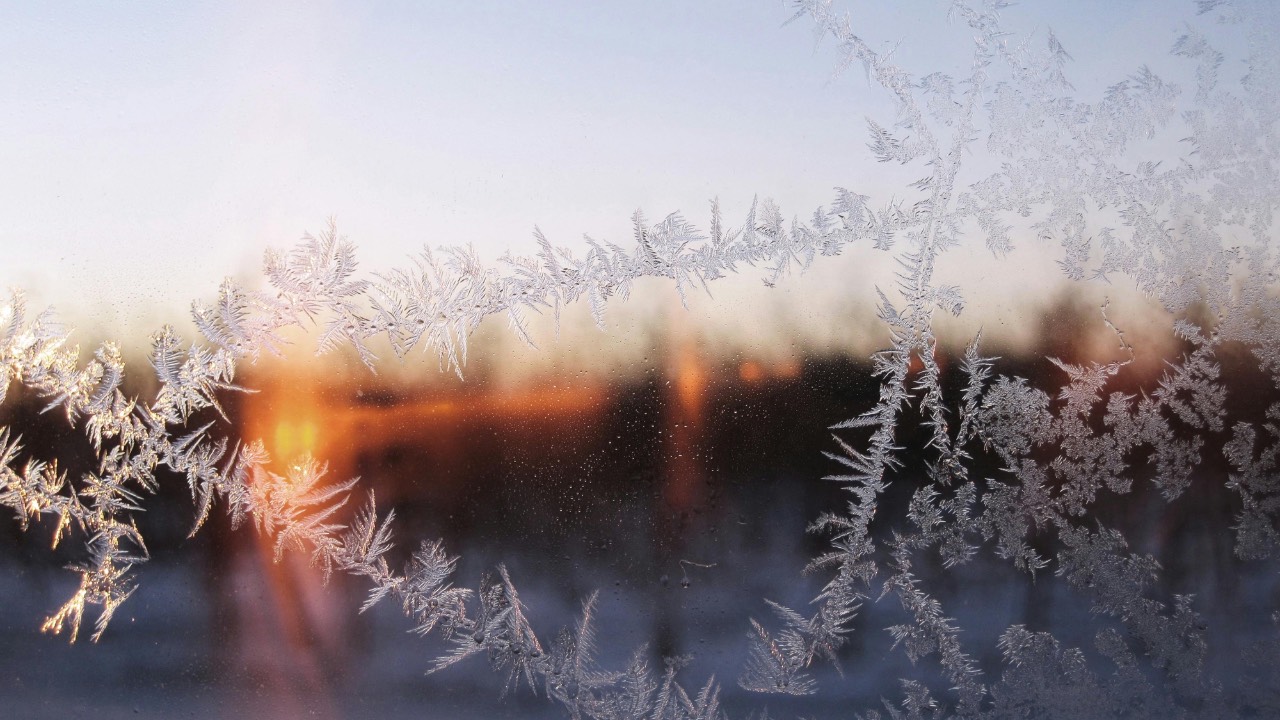 Frosted window, sunrise in distance