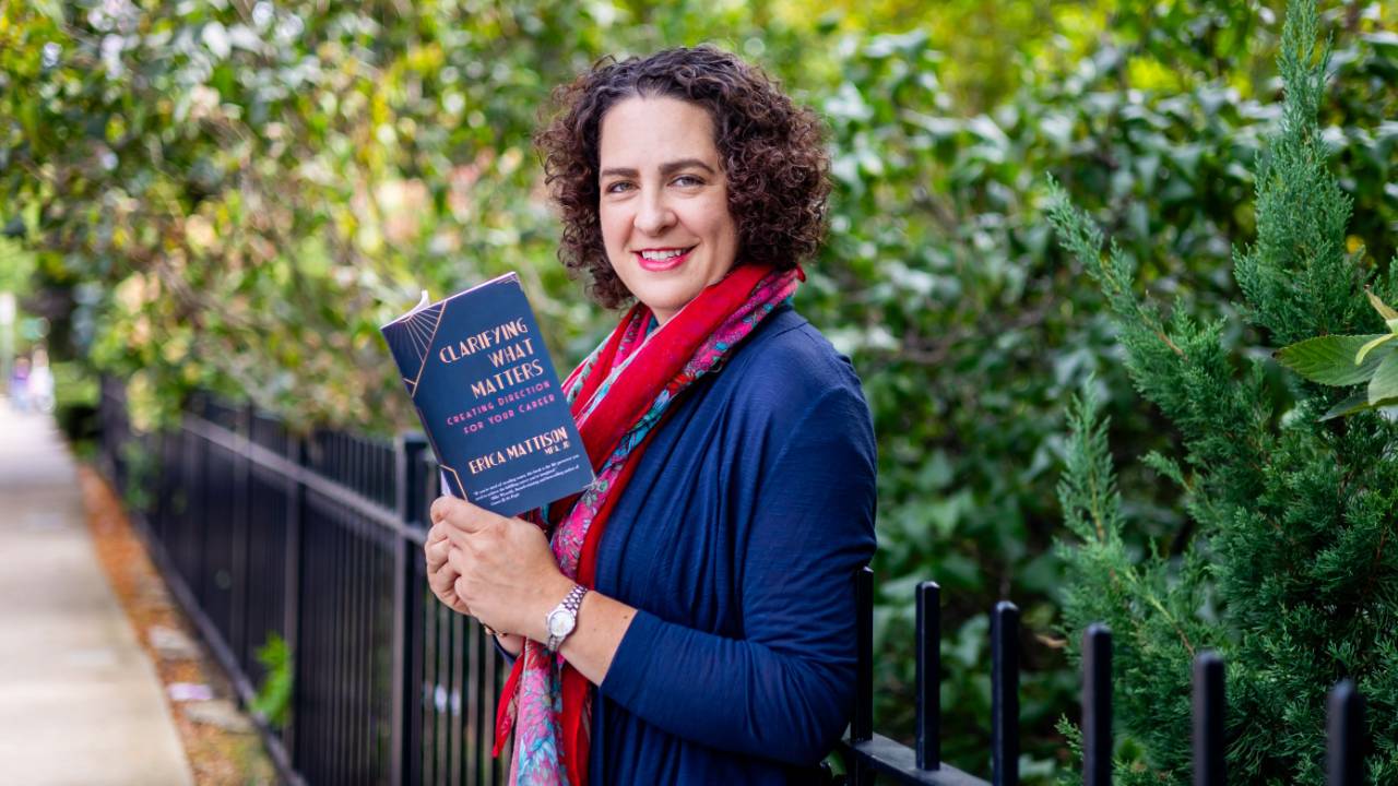Erica Mattison holding a copy of her book Clarifying What Matters