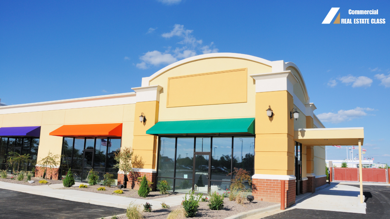 Modern strip shopping center with multiple storefronts and parking lot representing retail commercial real estate investment opportunities.