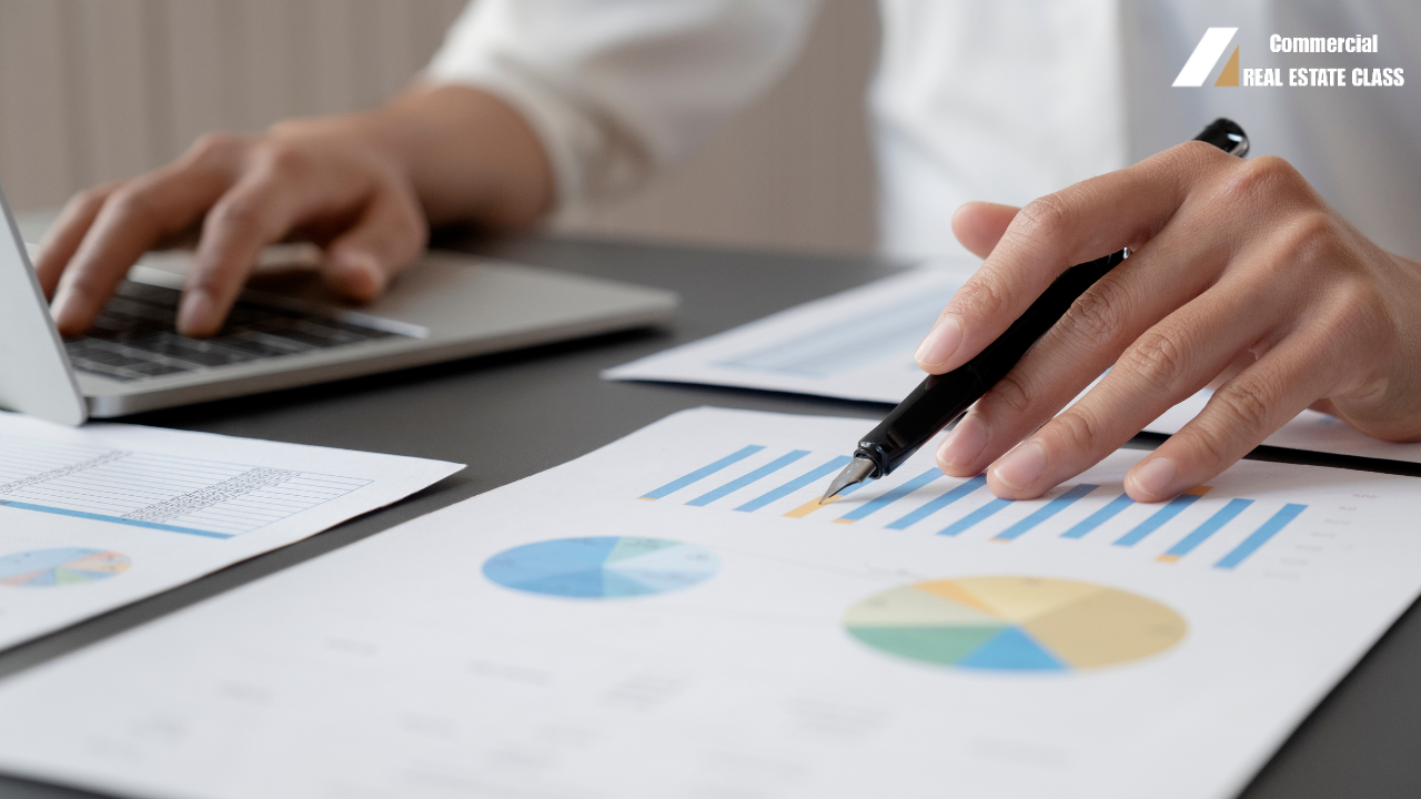 Commercial real estate investors reviewing financial documents while analyzing an income-producing investment property deal.