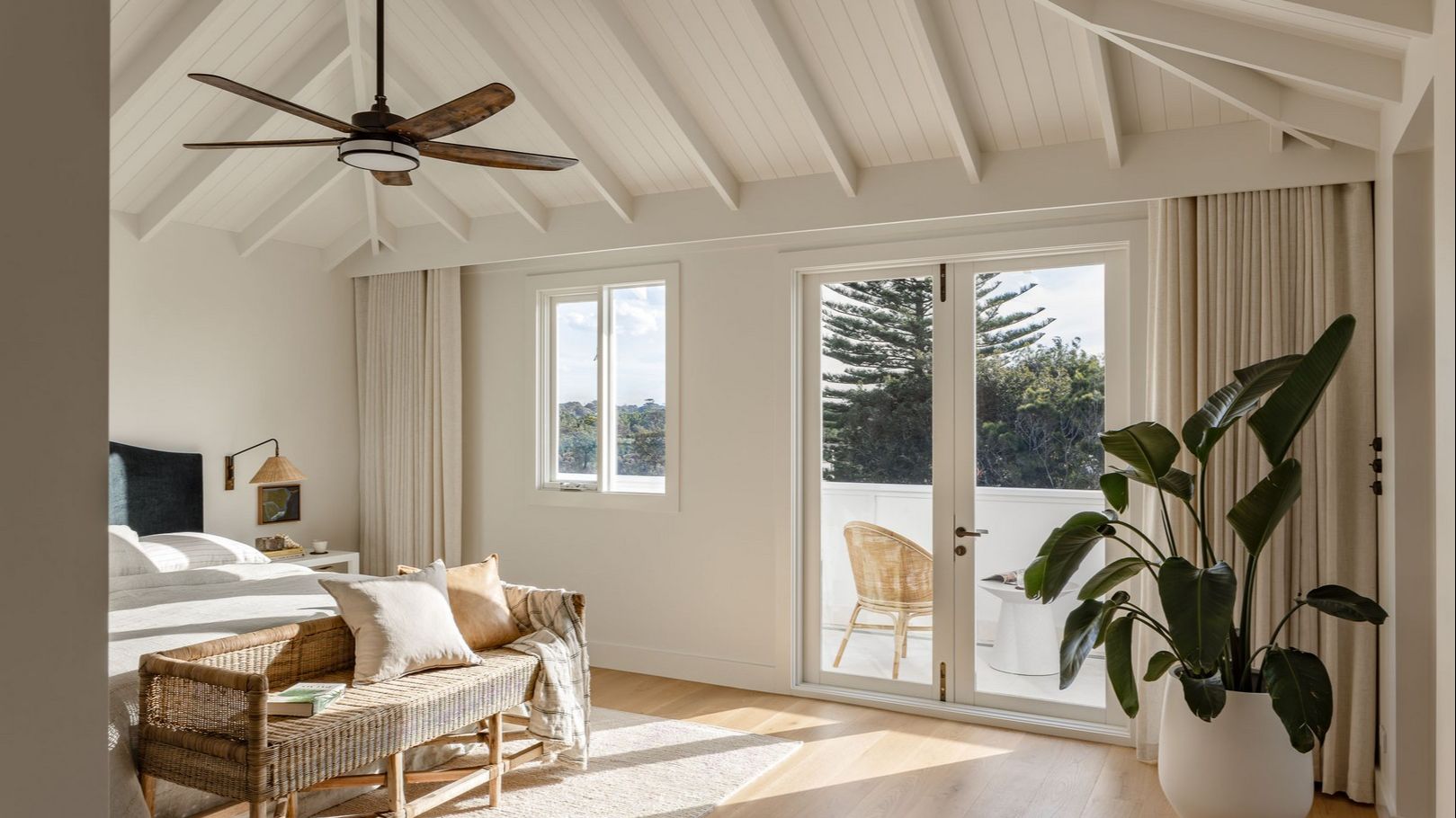 Coastal style bedroom with cathedral ceiling