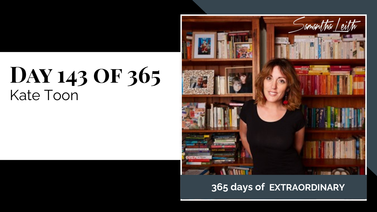Blog image for Day 143 of Sam Leith's '365 Days of Extraordinary' series, featuring a portrait of Kate Toon, a smiling woman with shoulder-length brown hair, wearing a black top, posing in front of two tall, wooden bookshelves packed with colorful books, indicating an interview or discussion about an author/SEO expert.