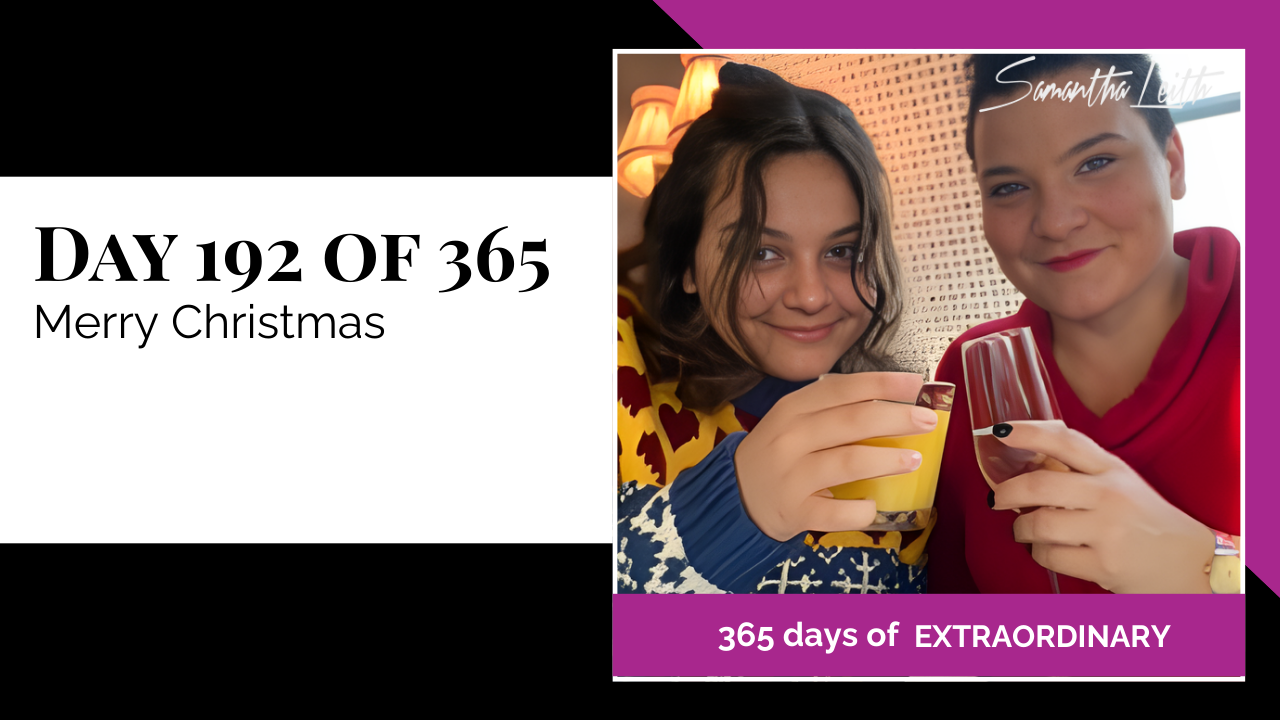 A warm, close-up photograph of two women smiling and raising glasses for a holiday toast in a cozy indoor setting, used to illustrate a blog post celebrating Christmas Day, family gatherings, and holiday cheer.