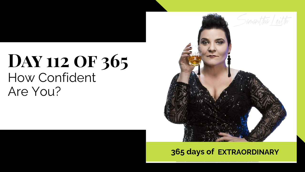 Blog image for Day 112 of Sam Leith's '365 Days of Extraordinary' series, featuring the author Samantha Leith looking confidently at the camera while holding a glass of amber liquid, wearing a shimmering black dress and large earrings.