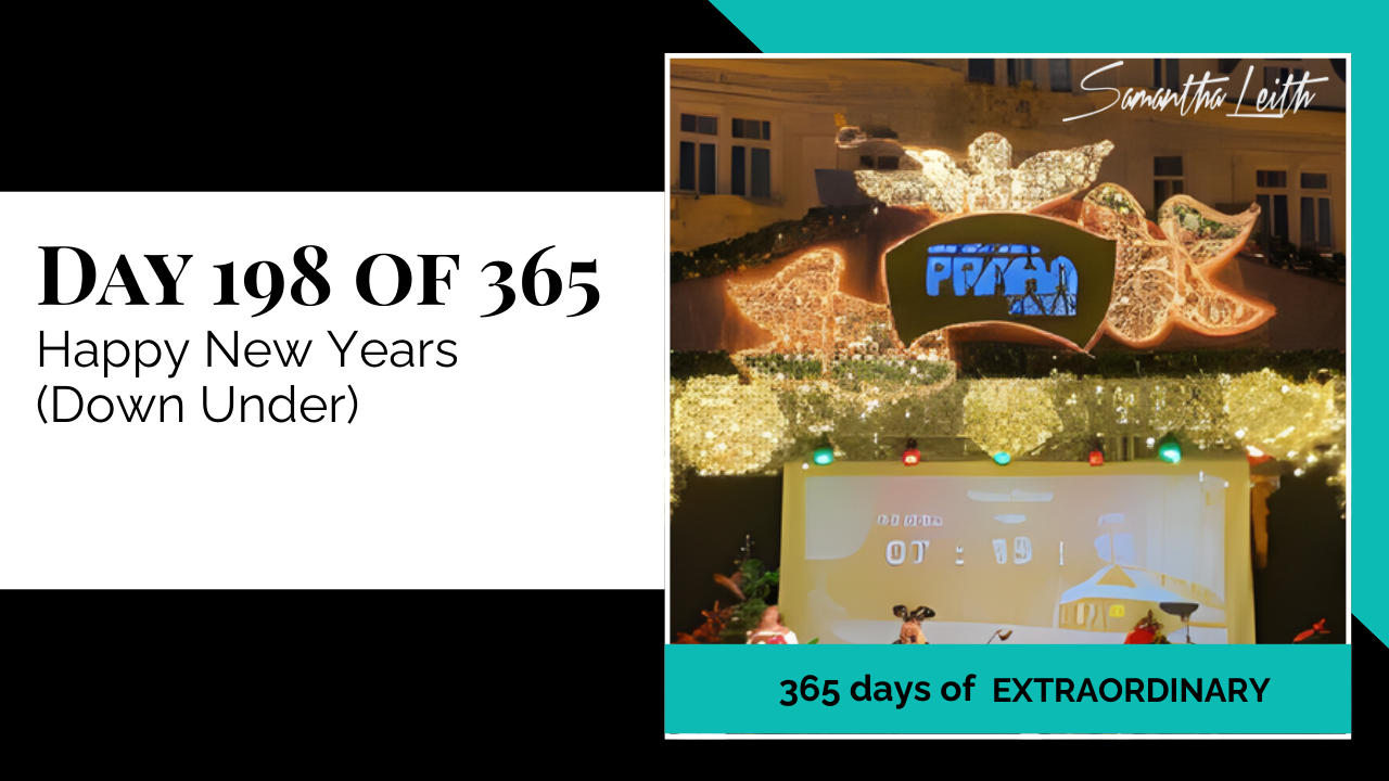 A lively nighttime photo of a major outdoor New Year's Eve celebration, showing a stage area with bright light installations and a timer, used to capture the energy and festivities of the New Year holiday in the Southern Hemisphere ("Down Under").