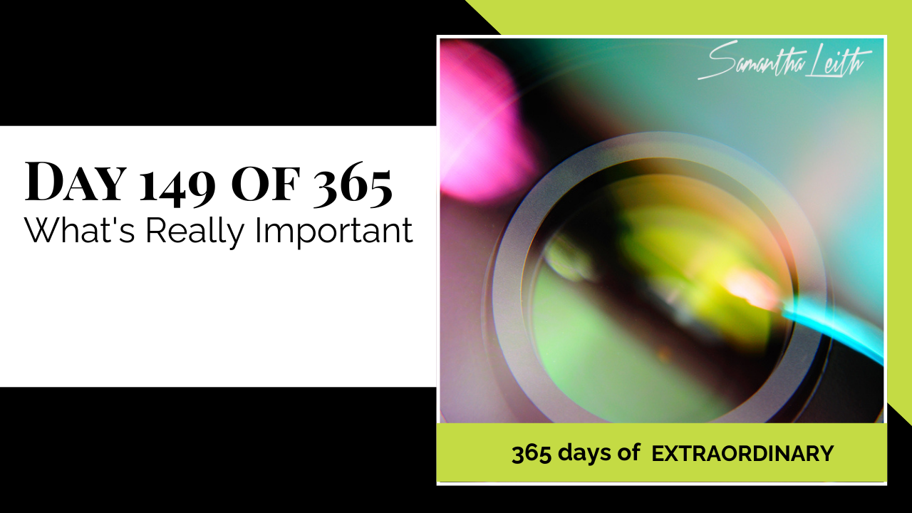 Social media graphic for Samantha Leith's "365 Days of Extraordinary" series. The post is for "Day 149 of 365: What's Really Important," featuring an abstract photo of a camera lens ring with colorful bokeh and light leaks, representing gaining clarity, improving focus, and prioritizing life goals.