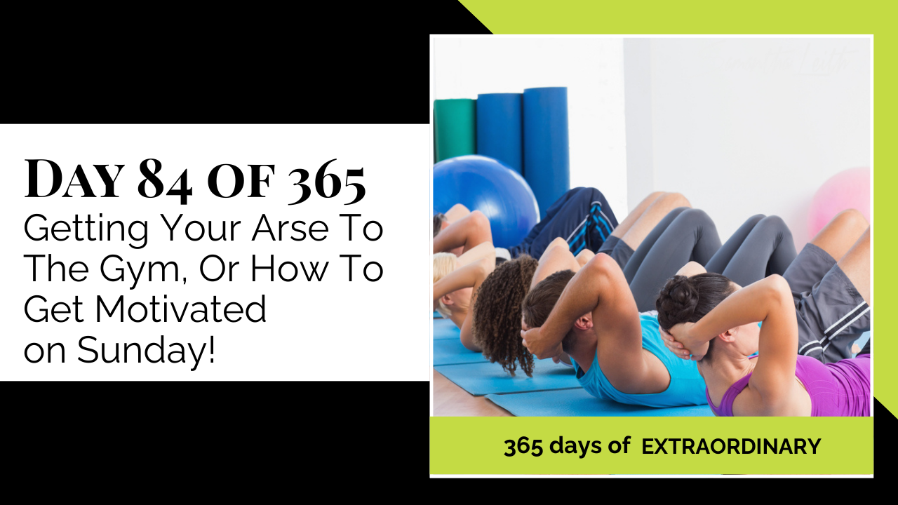 Blog thumbnail for 'Day 84 of 365: Getting Your Arse To The Gym.' The image shows a group of diverse people doing crunches or sit-ups on mats in a brightly lit gym, symbolizing motivation, fitness, exercise, and getting a Sunday workout in.