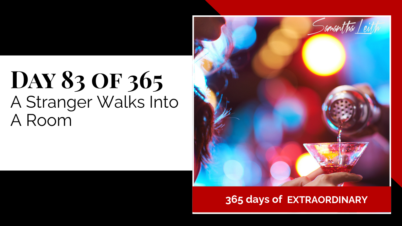 Blog thumbnail for 'Day 83 of 365: A Stranger Walks Into A Room.' The image features a hand pouring a drink into a cocktail glass against a bright, blurred bar background, symbolizing stepping into a new social or professional environment and making a first impression.