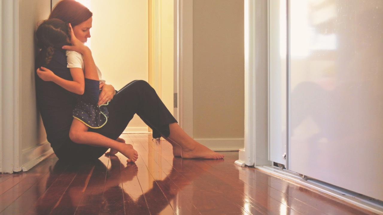 Mother sitting on floor embracing young daughter in moment of comfort and connection, representing healing generational patterns and breaking cycles of childhood wounds