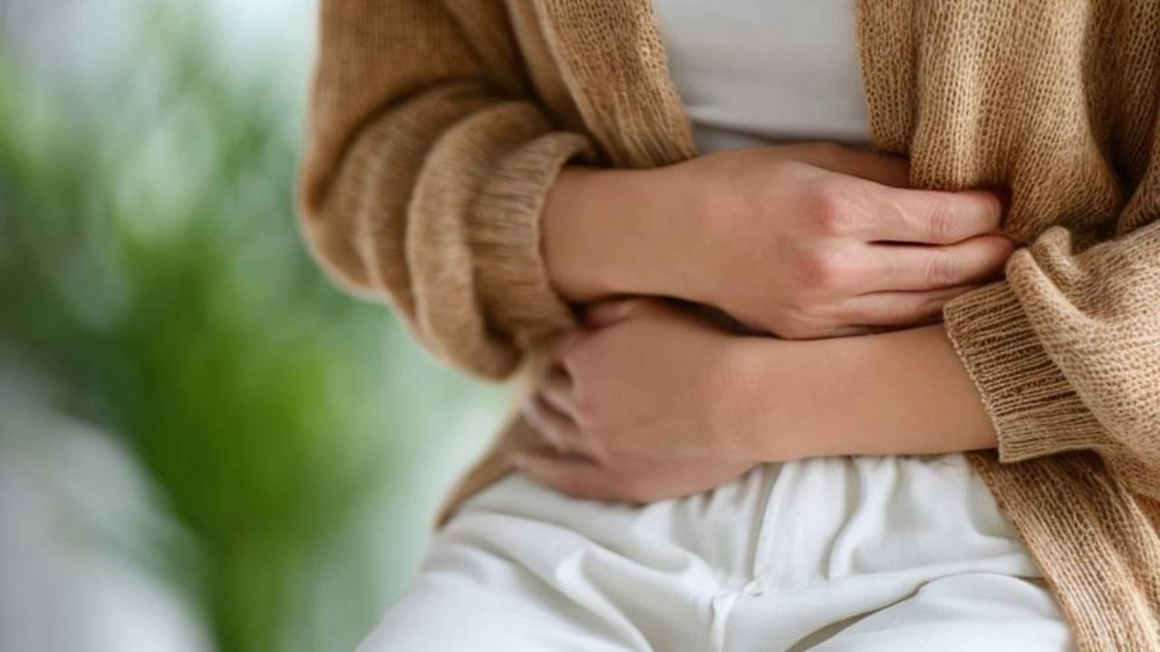 Woman holding bloated stomach in discomfort from SIBO during perimenopause