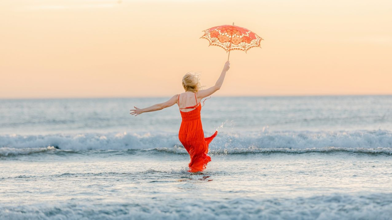 Woman embracing transformation at sunset - intermittent fasting journey for women over 40