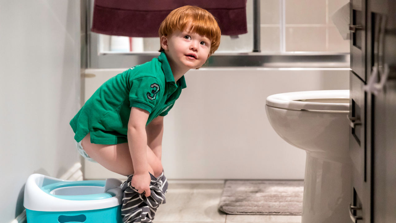 Boy sits down on the potty during potty training