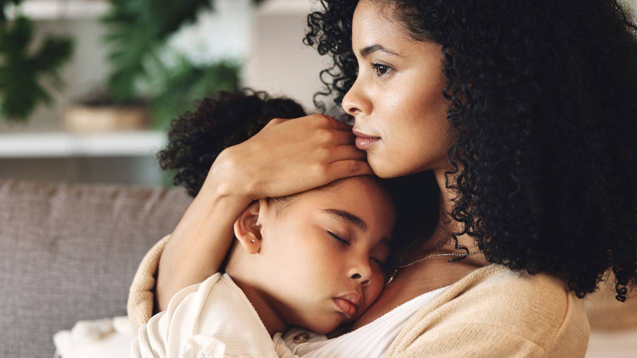 Parent qui tient son enfant endormi dans ses bras au moment du coucher