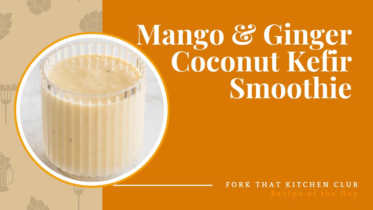 Pale yellow mango ginger smoothie in a clear glass on a white marble surface