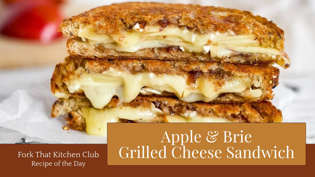 Three halves of apple and brie grilled cheese sandwich stacked on white plate on light gray surface, golden-brown whole grain bread with melted brie cheese oozing between layers and visible apple slices