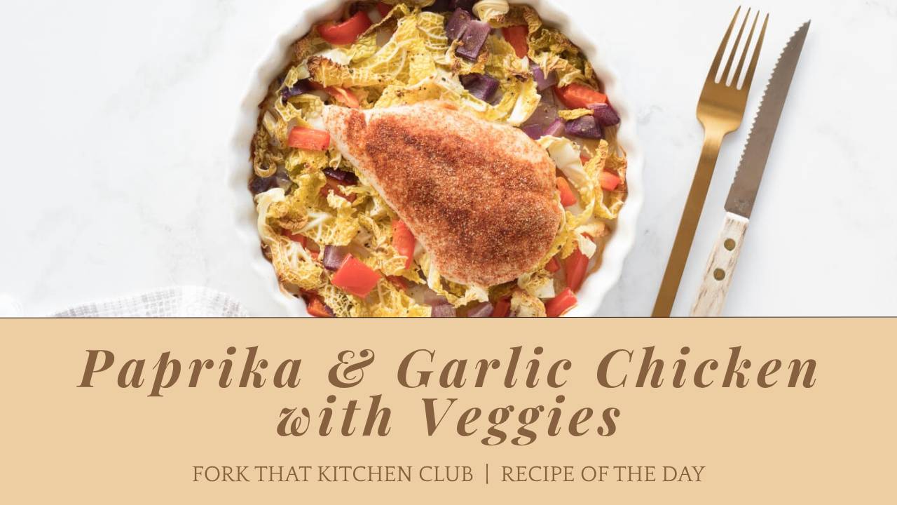 Paprika and garlic seasoned chicken breast on a bed of roasted red bell peppers, savory cabbage, and red onions in a white baking dish