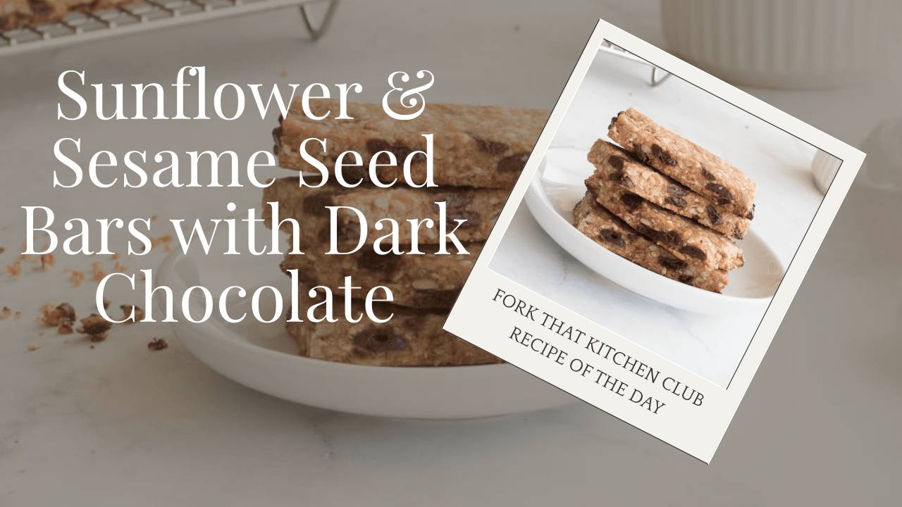 Stack of golden seed bars studded with chocolate chips on white plate, edge of cooling rack visible in background