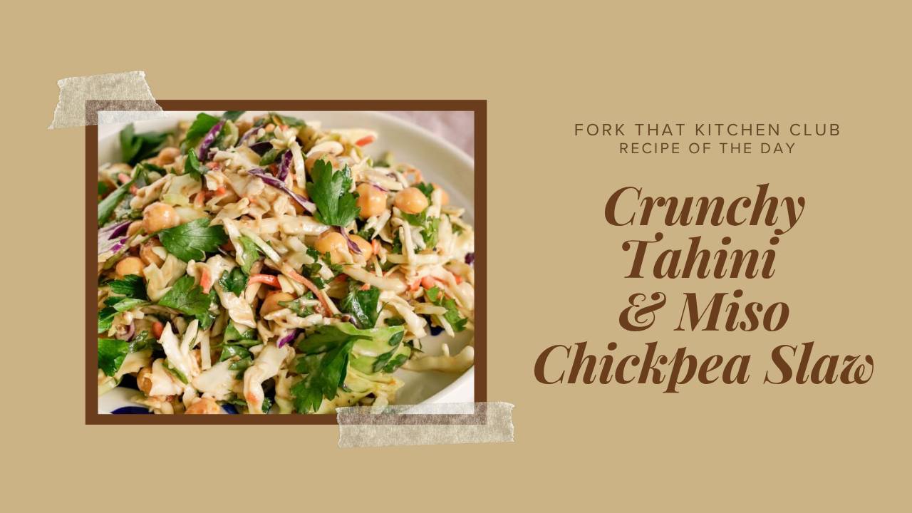 Colorful chickpea slaw with shredded purple and green cabbage tossed in creamy tahini miso dressing, garnished with parsley on white plate