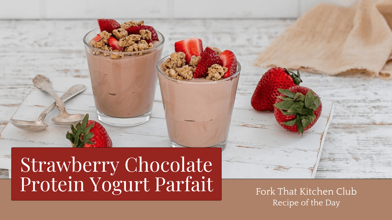 Two glass cups filled with chocolate protein yogurt parfait topped with sliced strawberries and granola, placed on white wooden surface with fresh whole strawberries beside them. High-protein breakfast recipe featuring Greek yogurt, cocoa powder, and fresh fruit in layered dessert-style presentation. Gluten-free option when using certified gluten-free granola.