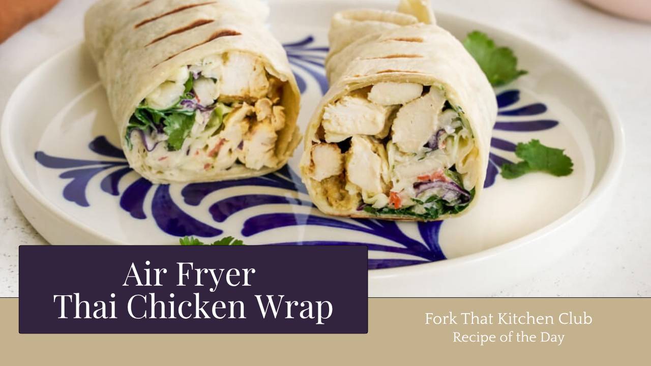 Two golden-brown Thai chicken wraps cut in half on a white plate, showing layers of sliced chicken, coleslaw, and fresh cilantro inside whole wheat tortillas.