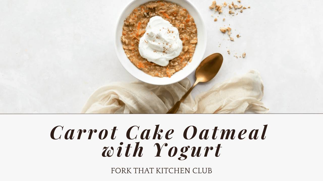 A white bowl of carrot cake oatmeal topped with a generous dollop of white Greek yogurt and sprinkled with cinnamon, photographed from above. A gold spoon rests beside the bowl on a light-colored surface with a beige linen napkin. Chopped walnuts are scattered on the surface near the bowl.