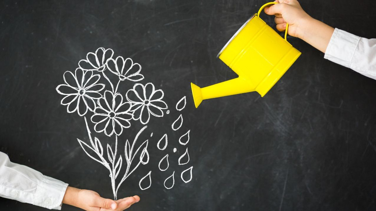 Yellow watering can watering flowers