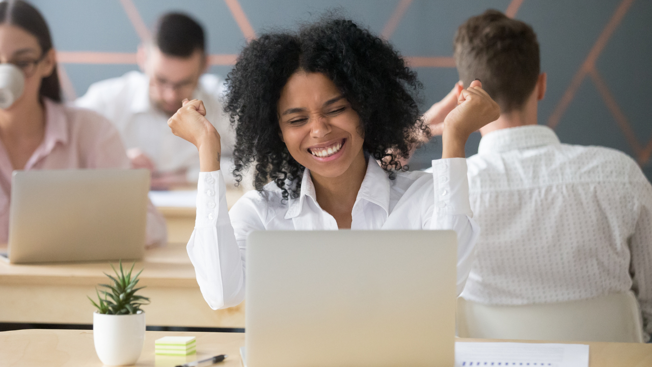 WOMEN CHEERING HERSELF AT A LAPTOP