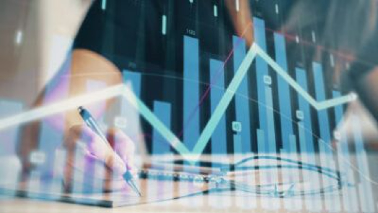 Person writing on a clipboard with a digital overlay of bar charts and a rising line graph