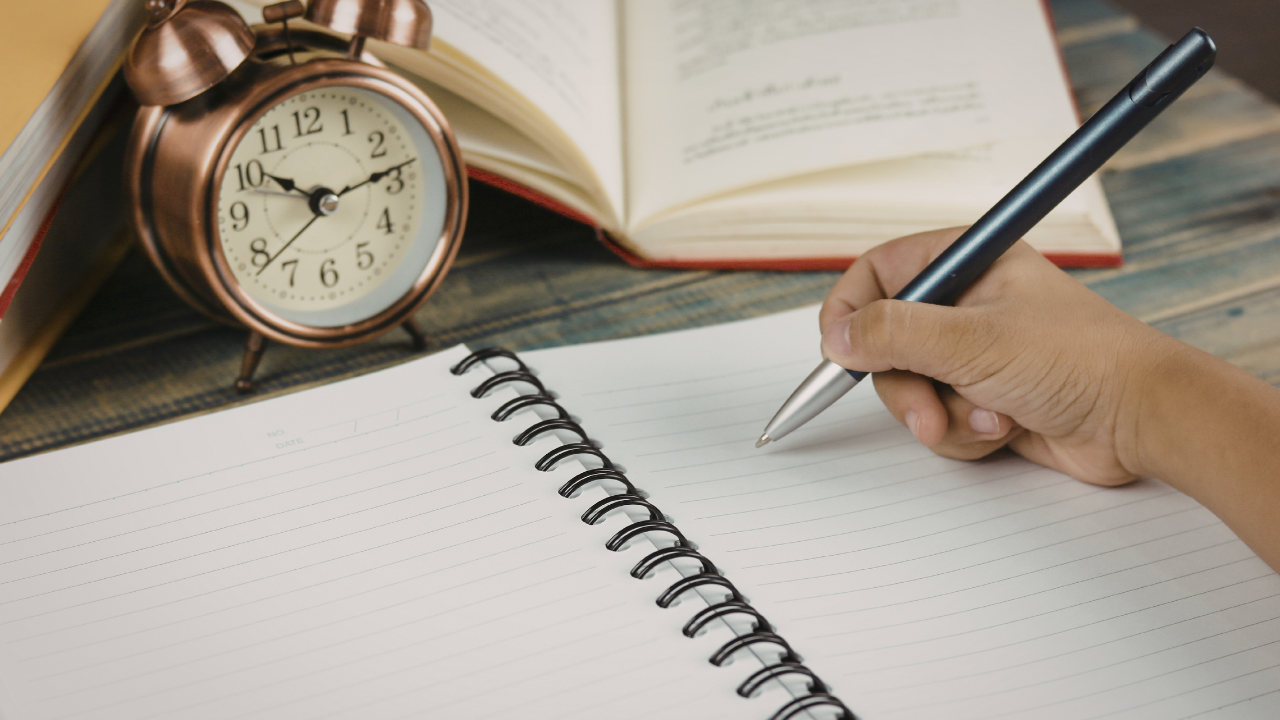 writing on a paper with a clock