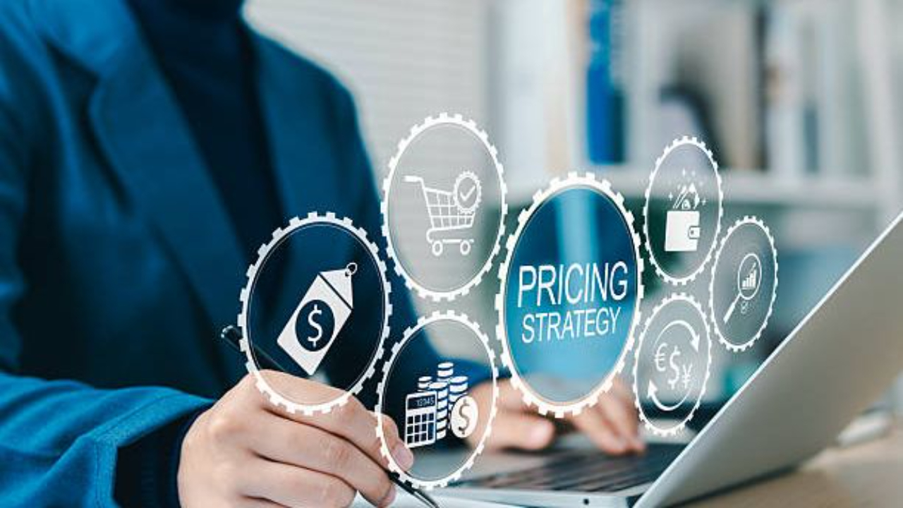 A person working at a laptop with digital icons representing ecommerce pricing strategy, including price tags, shopping carts, and financial charts.