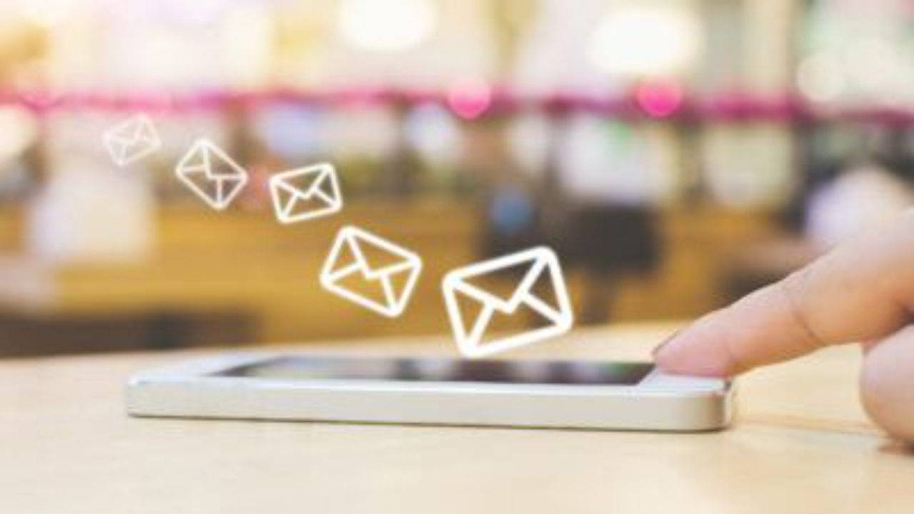Person tapping a smartphone with illustrated email icons appearing above the screen
