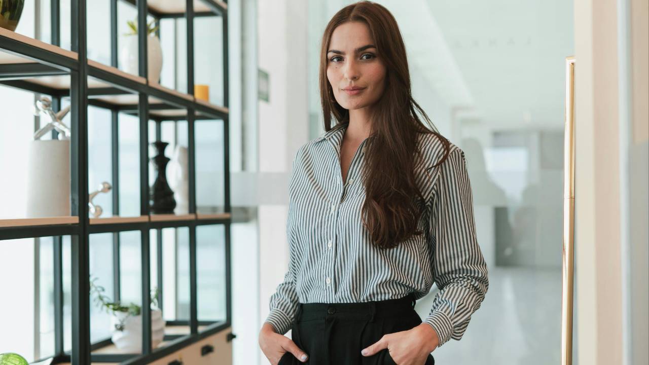 Confident professional woman standing in a modern office, symbolizing women’s leadership, strength, and independence on International Women’s Day.