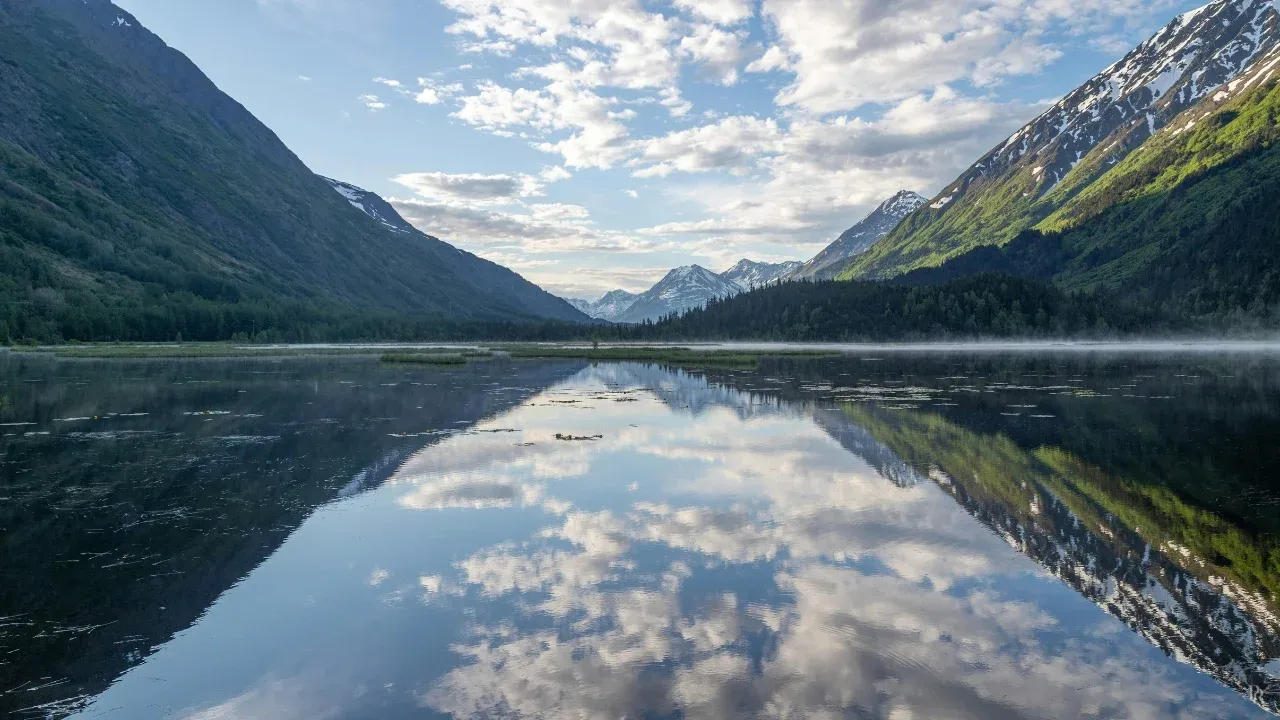 Still lake with mountain reflection representing calm clarity after disorientation