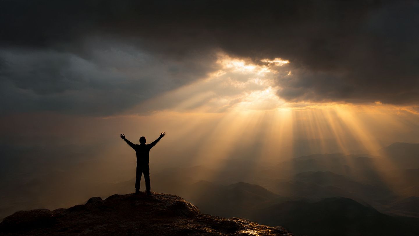 Christian standing firm in prayer at sunrise, symbolizing victory over darkness