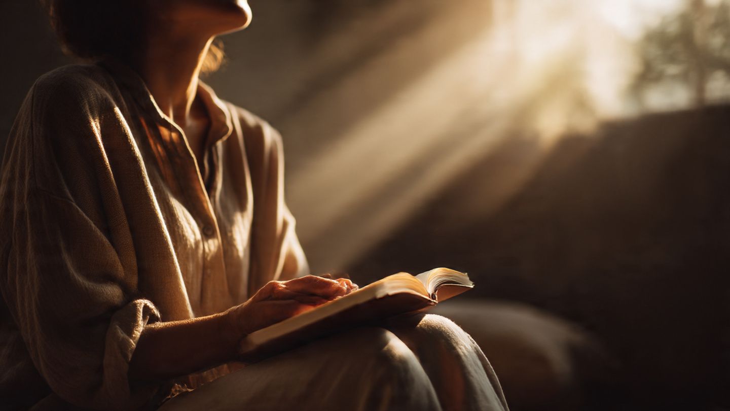 Person journaling in morning light, symbolizing gratitude and spiritual reflection.